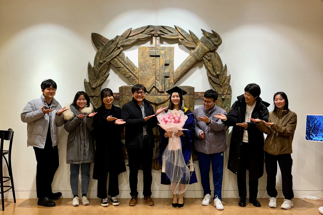 Lab members celebrating with a bouquet, February 2024